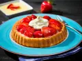Erdbeerkuchen mit fertigboden, belegt mit frischen Erdbeeren und Sahne, auf einem blauen Teller.