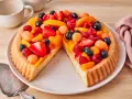 Ein leckerer Obstboden belegt mit Erdbeeren, Himbeeren, Blaubeeren, Aprikosen und Melonenbällchen.