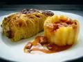 Ein goldbraunes Kohlrouladen-Rezept auf einem Teller, serviert mit Kartoffelpüree und einer herzhaften Sauce.