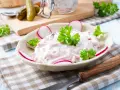 Ein cremiger Fleischsalat, garniert mit Radieschen und Petersilie. Ein einfaches und leckeres rezept fleischsalat für jede Gelegenheit.