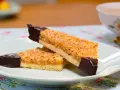 Zwei Nussecken mit Schokoladenspitze auf einem Teller, bereit zum Genießen. Ein köstliches nussecken rezept.