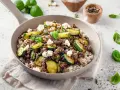Herzhafte zucchini hackfleisch pfanne mit Reis und Feta, garniert mit frischem Basilikum.