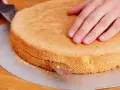 Ein Tortenboden wird mit einem Messer geteilt. Dieses einfache Tortenboden Rezept gelingt immer.