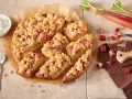 Ein saftiger Rhabarberkuchen mit Streuseln, perfekt für ein Rhabarberkuchen Rezept. Dazu eine Schüssel Schlagsahne.