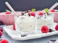 Leckeres Herrencreme Rezept: Cremiges Dessert mit Schokostückchen, frischen Himbeeren und Minze in Gläschen.