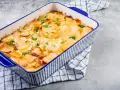 Ein goldbrauner Kartoffelauflauf, garniert mit Petersilie, bereit zum Servieren. Ein köstliches Kartoffelauflauf Rezept.