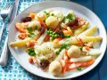 Leipziger Allerlei: Spargel, Erbsen, Karotten, Blumenkohl, Garnelen und Morcheln auf einem Teller.