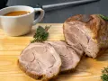 Saftiger Schweinenacken, aufgeschnitten und mit Soße serviert. Ein köstliches Schweinenacken Rezept für jeden Anlass.