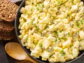 Cremiger Eiersalat mit Gurkenstückchen und Schnittlauch, perfekt für ein einfaches eiersalat rezept. Dazu passen rustikale Brotscheiben.