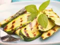 Gegrillte Zucchinischeiben mit Grillstreifen, garniert mit frischem Basilikum. Perfekt für die Sommerküche, diese Zucchini grillen marinade ist ein Genuss.
