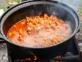 Ein dampfender Kessel mit herzhaftem Kesselgulasch, zubereitet über offenem Feuer. Das perfekte Rezept für ein rustikales Outdoor-Erlebnis.