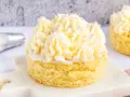 Ein kleiner Kuchen mit omas buttercreme ohne pudding, verziert mit lila Zuckerstreuseln.