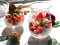 Zwei Gläser mit einem leichten Erdbeer Quark Dessert, garniert mit frischen Erdbeeren und Minze.