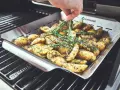 Kartoffeln mit Rosmarin und Thymian in einer Grillpfanne. Perfekt für die Drillinge Kochzeit auf dem Grill.