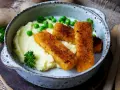 Knusprige Fischstäbchen auf cremigem Kartoffelbrei mit Erbsen und Petersilie – schnelle Gerichte mit Kartoffelbrei, die immer schmecken.