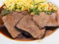 Saftige Scheiben Sauerbraten mit Spätzle und einer Kräutergarnitur. Ein klassisches Sauerbraten Rezept, das Appetit macht.