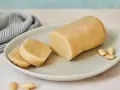 Frisch zubereitetes Marzipan zum **Marzipan selbst machen**. Ein Block und zwei Scheiben liegen auf einem Teller, daneben Mandeln.