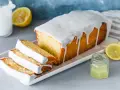 Saftiger Zitronenkuchen mit Zuckerguss, perfekt für ein einfaches zitronenkuchen rezept. Serviert mit frischen Zitronenscheiben.