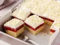 Schichtkuchen mit roter Fruchtschicht, weißer Creme und Schokostreuseln – perfekt als Kuchen zum Muttertag.