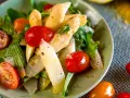 Ein Teller mit weltbestem Spargelsalat, garniert mit Kirschtomaten und frischen Kräutern. Ein Genuss für Augen und Gaumen.