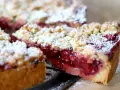Ein saftiger Kirschstreuselkuchen, bestäubt mit Puderzucker, wartet darauf, genossen zu werden.