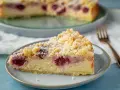 Ein Stück saftiger, schneller Quark Kirsch-Kuchen mit Streuseln und Puderzucker bestäubt.
