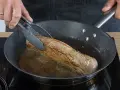 Ein saftiges Schweinefilet brät in der Pfanne. Einfache Rezepte für zartes Fleisch in der Pfanne gelingen so.