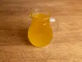 Ein kleines Glas mit goldgelbem Butterschmalz steht auf einem Holzbrett. Perfekt zum butterschmalz selber machen.