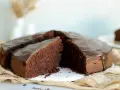 Ein saftiger Schokokuchen mit glänzender Glasur, perfekt für jedes schokokuchen rezept. Ein Stück ist bereits angeschnitten.