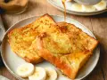 Armer Ritter, goldbraun gebraten, mit Sirup übergossen und Bananenscheiben garniert. Ein köstliches Frühstück!