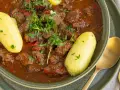 Herzhaftes Gulasch im Schnellkochtopf, serviert mit Salzkartoffeln und frischer Petersilie. Ein Klassiker, der schnell zubereitet ist.