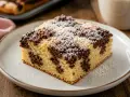 Ein Stück saftiger Wolkenkuchen mit Schokostreuseln und Puderzucker. Dieses Wolkenkuchen Rezept ist ein Genuss!