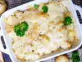 Herzhafter Blumenkohl Auflauf mit geschmolzenem Käse und frischer Petersilie, garniert mit Pfeffer.