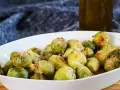 Ein weißes Ovalschälchen gefüllt mit knusprigem Rosenkohl, bestreut mit Parmesan und Chili-Flocken.