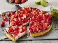 Saftiger Erdbeerkuchen mit frischen Erdbeeren, Sahne und gehackten Pistazien. Ein Traum für alle, die Rezepte mit Erdbeeren lieben!