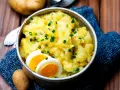 Omas Kartoffelsalat, cremig und mit Schnittlauch bestreut, serviert mit gekochten Eiern. Ein Klassiker, der immer schmeckt.