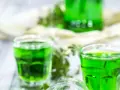 Grüne Gläser mit Waldmeistersirup, perfekt zum Waldmeistersirup selber machen. Frische Kräuter und ein Hauch von Frühling.