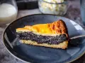 Ein saftiges Stück Mohnkuchen mit Pudding-Schicht auf einem blauen Teller, bereit zum Genuss.