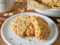 Zwei goldbraune Haferkekse liegen auf einem weißen Teller. Ein leckeres haferkekse rezept zum Nachbacken.