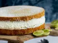 Saftige Quark Sahne Torte mit frischen Limettenspalten, bestäubt mit Puderzucker.