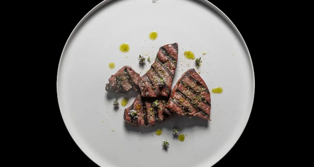 Gebratene Leberstücke mit Kräutern und Olivenöl auf einem weißen Teller. Ein einfaches, aber köstliches Leber Rezept.