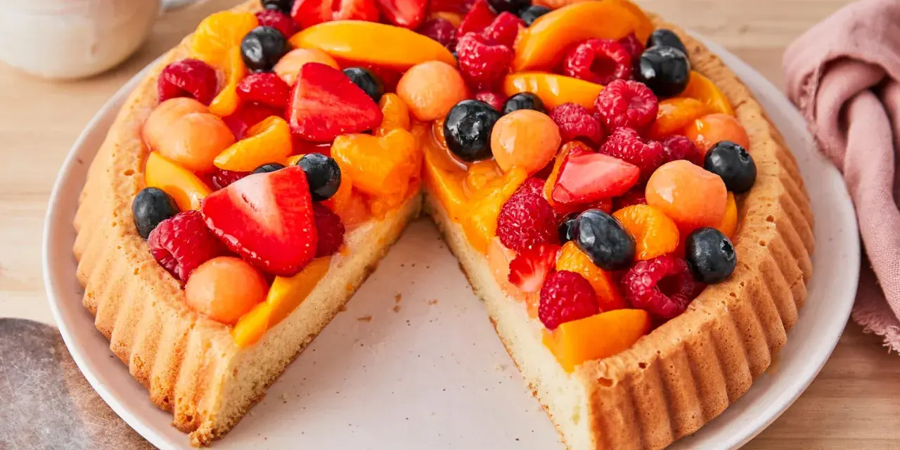 Ein leckerer Obstboden belegt mit Erdbeeren, Himbeeren, Blaubeeren, Aprikosen und Melonenbällchen.