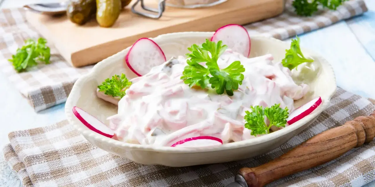 Ein cremiger Fleischsalat, garniert mit Radieschen und Petersilie. Ein einfaches und leckeres rezept fleischsalat für jede Gelegenheit.