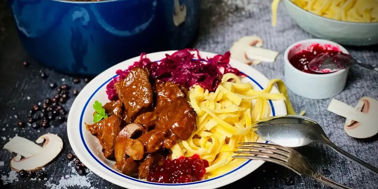 Herzhaftes Rehgulasch mit Spätzle, Rotkohl und Preiselbeeren. Ein köstliches Rehgulasch Rezept für Genießer.