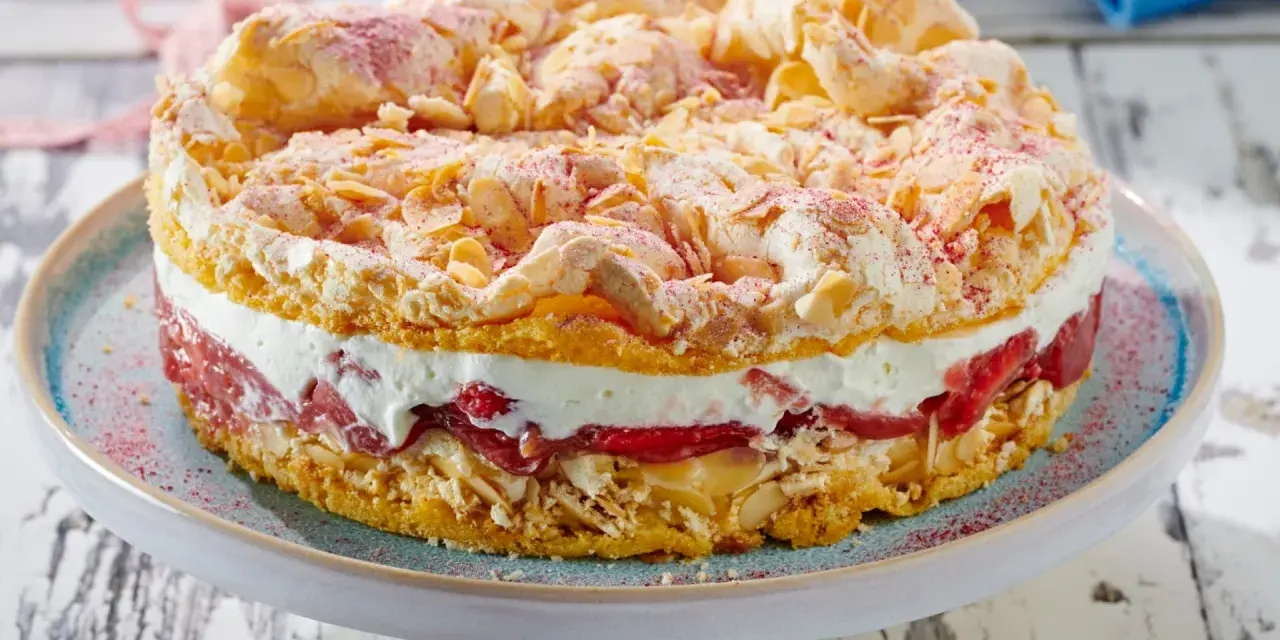 Ein köstlicher Rhabarberkuchen mit Baiser, wie ihn Landfrauen backen. Mit Mandelsplittern und roter Puderzucker-Deko.