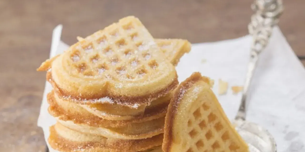 Herzförmige Waffeln, bestäubt mit Puderzucker. Ein perfektes Rezept für süße Momente.