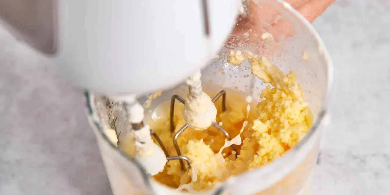 Hand mixt Sahne zu Butter. Der Prozess, um Butter selber machen, ist faszinierend.
