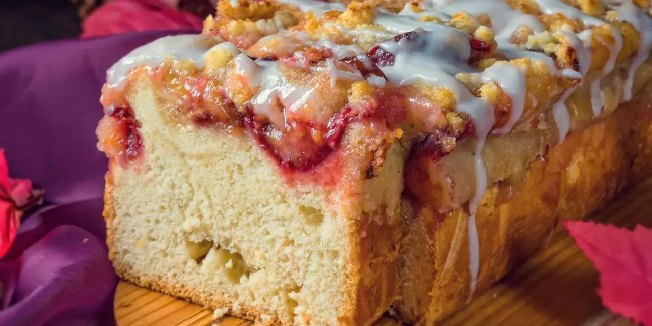 Saftiger Pflaumenkuchen in Kastenform, mit Streuseln und Zuckerguss überzogen, bereit zum Genießen.