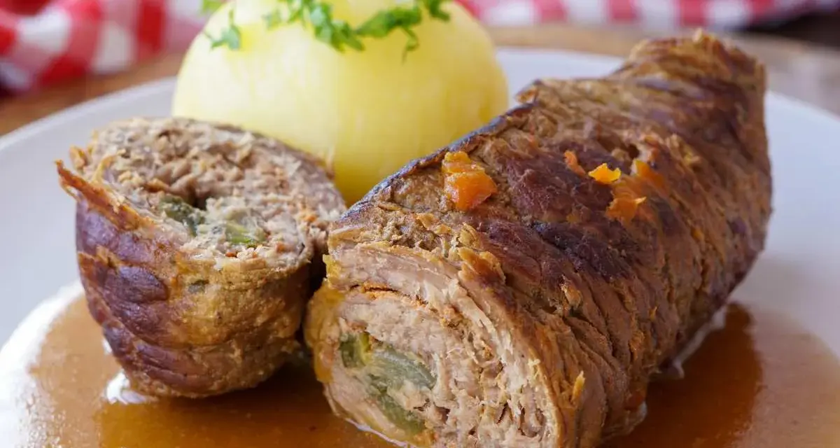 Herzhaftes Rouladen Rezept: Zarte Rinderrouladen mit Kartoffelklößen in einer kräftigen Soße, garniert mit Petersilie.