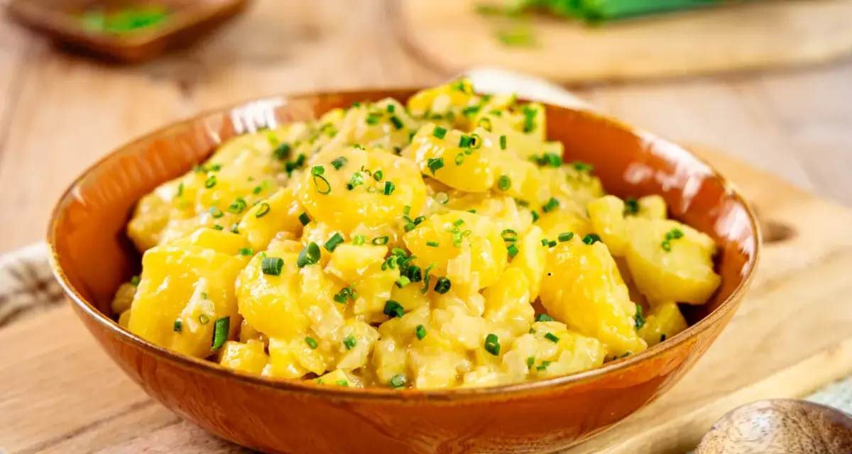 Ein köstlicher Kartoffelsalat, perfekt für jedes Kartoffelsalat Rezept. Mit frischen Kräutern garniert, bereit zum Servieren.